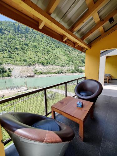 a balcony with two chairs and a table and a view at Bela Resorts Naran in Nārān