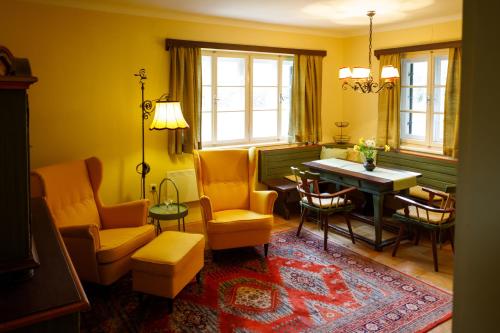 - un salon avec des murs jaunes, une table et des chaises dans l'établissement Ländliches Ferienhaus, à Kötschach-Mauthen