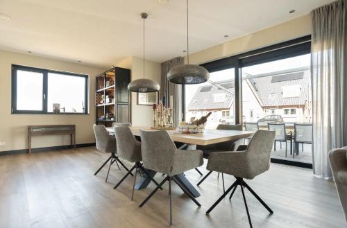 a dining room with a table and some chairs at New high end waterfront family villa in Stavoren
