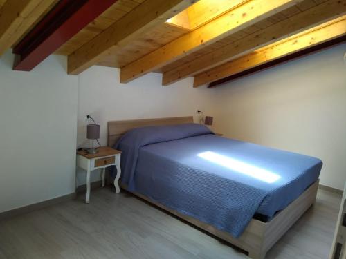 a bedroom with a blue bed and a table at Dreaming Feriolo - mansarded apartment by Danilo Apartments in Baveno