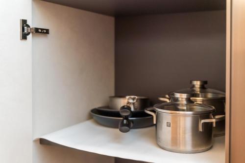 two pots and pans on a shelf in a kitchen at Il Loft di Quintino in Parma