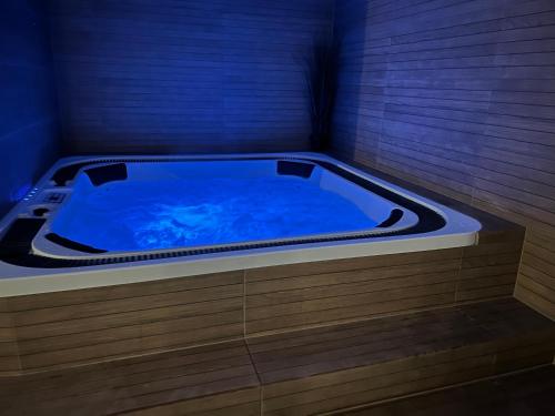 a jacuzzi tub in a room with a blue at Domek Mazury nad Jeziorem in Langendorf