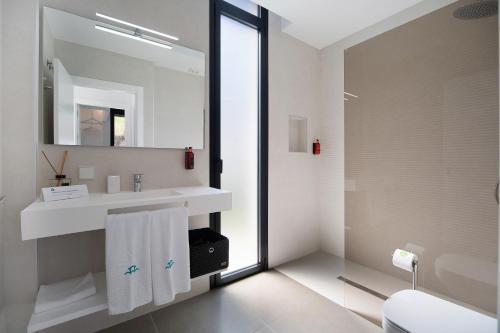 een badkamer met een witte wastafel en een spiegel bij Maria del Mar Sea Villa in Novo Sancti Petri