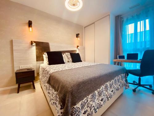 um quarto com uma cama, uma secretária e uma cadeira em Alicante - Turquesa Del Mar Suites - Luxury em Orihuela