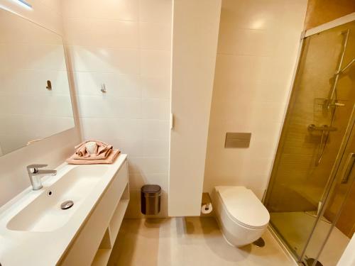 uma casa de banho branca com um lavatório e um WC em Alicante - Turquesa Del Mar Suites - Luxury em Orihuela