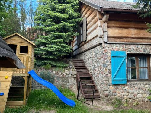 a house with a blue door on the side of it at Domek Mazury nad Jeziorem in Langendorf