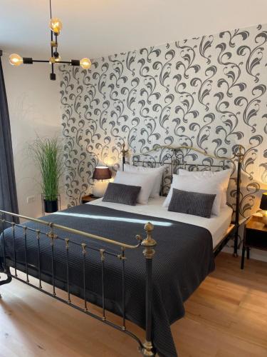 a bedroom with a black and white bed and a wall at Apartments CLIFF Piran in Piran