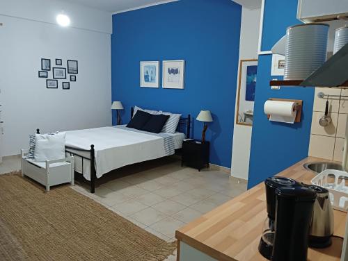 - une chambre avec un lit et un mur bleu dans l'établissement Amelie's Apartments, à Mesolongion