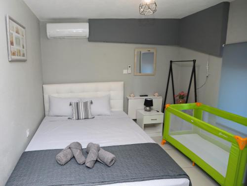 1 dormitorio con 1 cama con 2 zapatillas en iLposto Down, en Kavala