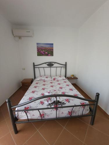 a bedroom with a bed with a floral bedspread at Nuovo Sun Golem in Golem