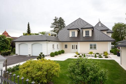 a white house with a black roof at Hüttenzauber & Turmchalet in Losensteinleithen
