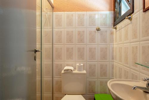 a bathroom with a toilet and a sink and a shower at Pousada Y-Goá in Bertioga