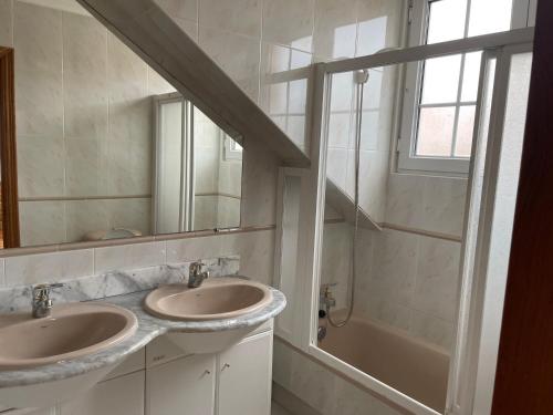 łazienka z 2 umywalkami, wanną i oknem w obiekcie Ermita San Vicente de la Barquera Duplex w mieście San Vicente de la Barquera