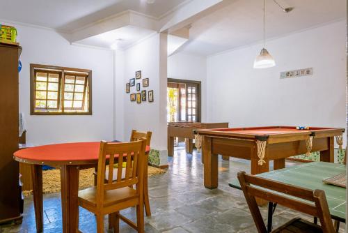 a room with a ping pong table and chairs at Pousada Y-Goá in Bertioga