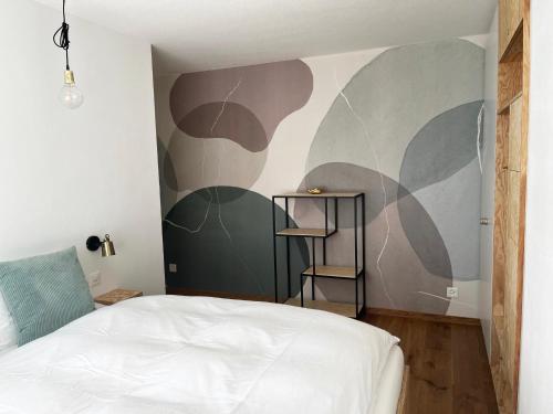 a bedroom with a bed and a wall with a mural at Haus Allod 208 in Lenzerheide