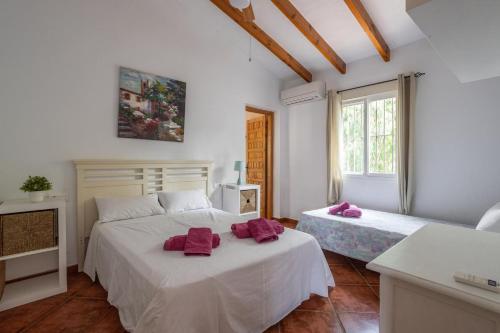 een slaapkamer met 2 bedden en handdoeken bij Villa Bárbara Piscina Vallada con Barbacoa Ideal Grupos By CostadelSolEscapes in Málaga