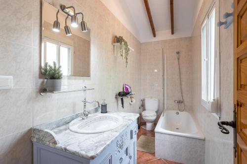 een badkamer met een wastafel, een bad en een toilet bij Villa Bárbara Piscina Vallada con Barbacoa Ideal Grupos By CostadelSolEscapes in Málaga