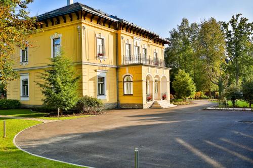 a yellow house with a driveway in front of it at Villa Aurelie in Velké Losiny