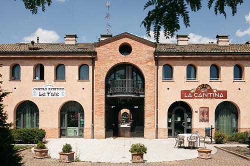 a brick building with tables and chairs in front of it at Appartamento incantevole parcheggio nel residence in Medolla