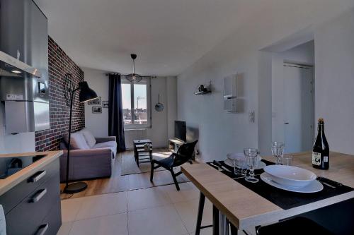 une cuisine et un salon avec une table et un canapé dans l'établissement Appartement INDU Centre ville de VITRÉ, à Vitré
