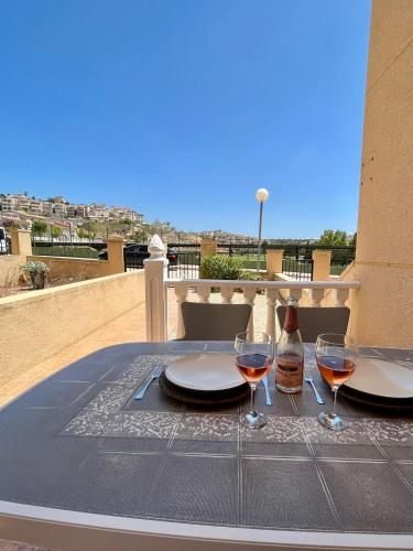 a table with two glasses and a bottle of wine at Tranquil Self Catering Golf Course Apartment in Alicante