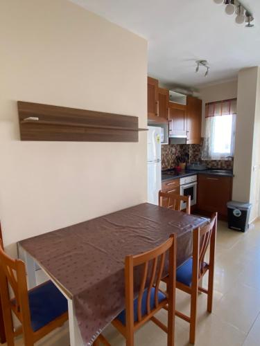 kuchnia z drewnianym stołem i krzesłami w pokoju w obiekcie Apartamento Primera Linea de Playa w mieście Oropesa del Mar