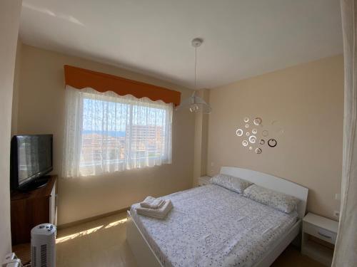 mała sypialnia z łóżkiem i oknem w obiekcie Apartamento Primera Linea de Playa w mieście Oropesa del Mar