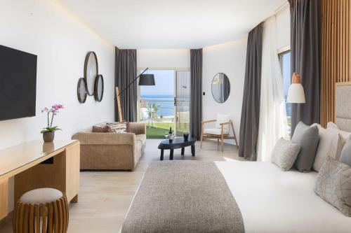 a hotel room with a bed and a living room at Atlantica Bay - Adults Only in Limassol
