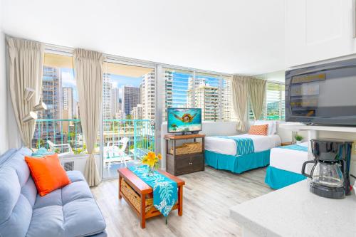 Una sala de estar con un sofá azul y una ventana grande. en Cozy Waikiki Studio at Aqua Aloha Surf, en Honolulu