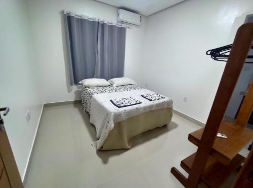 ein Schlafzimmer mit einem Bett in einem Zimmer mit einem Fenster in der Unterkunft TAPERAPUAN in Porto Seguro