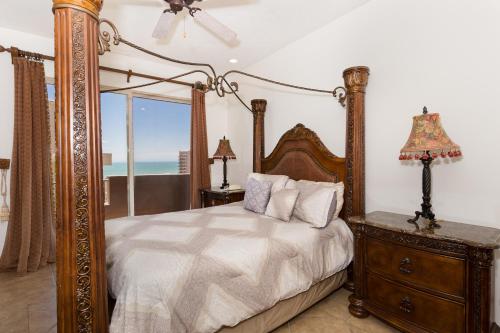 - une chambre avec un lit à baldaquin et une vue sur l'océan dans l'établissement Bella Sirena 601-B -Stylish Condo in Oceanfront Resort, à Puerto Peñasco