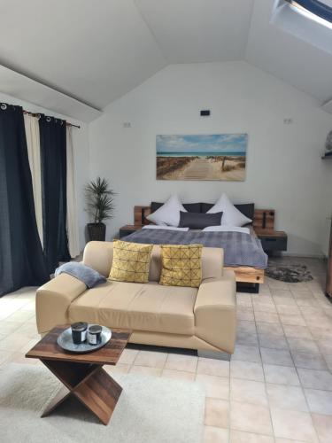 a living room with a couch and a bed at Nordsee Cottage Ava in Niebüll