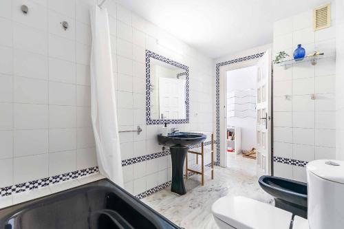 a bathroom with a black tub and a sink at Sur Suites Astigi Vista Mar in Fuengirola