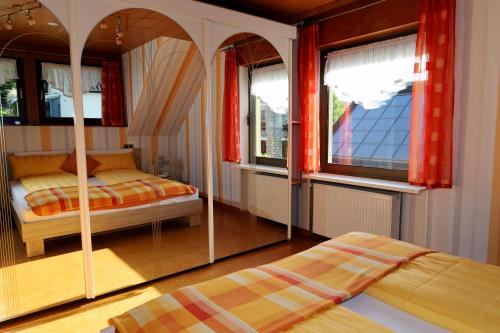 a bedroom with two beds and two windows at Lahn-er-leben in Geilnau