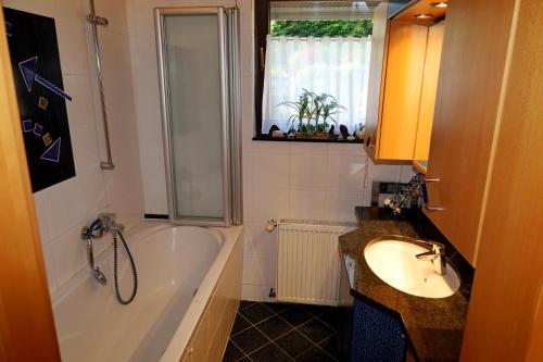 a bathroom with a tub and a sink and a bath tub at Lahn-er-leben in Geilnau