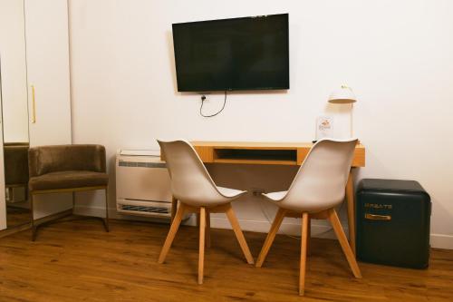 two chairs and a desk with a television on a wall at La Villa bed & breakfast in Milan