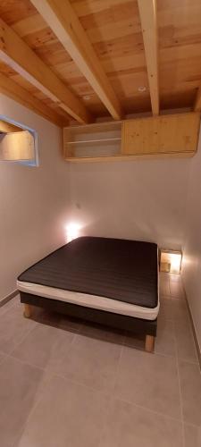 un letto in una stanza con soffitto di Studio les 3 cirques a Gèdre