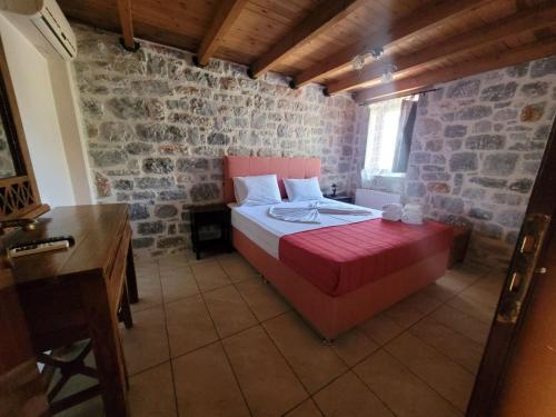 a bedroom with a large bed in a stone wall at Althea Village in Areopolis