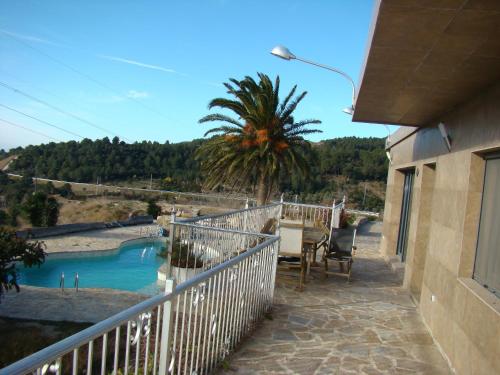 a balcony with a table and chairs and a palm tree at Can Clapa in Les Borges del Camp