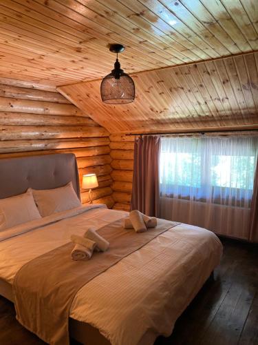 a bedroom with a bed with two towels on it at Bellevue Chalet in Râşnov