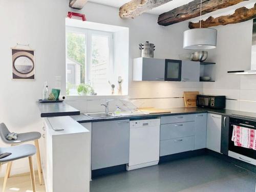 une cuisine avec des armoires blanches, un évier et une fenêtre dans l'établissement ENTIRE HOUSE - Familly Home Cosy&Relax StMalo-Dinan-Rennes-MtStMichel, à Saint-Thual
