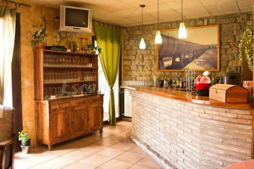 un bar con TV en la parte superior de una pared de ladrillo en Casa rural marga, en Tardienta