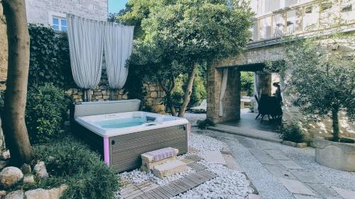 a bath tub sitting next to a building at Rector's Villa - Charming Retreat in Old Town with Jacuzzi in Private Courtyard in Rab