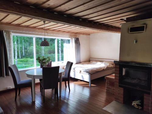 een kamer met een tafel en een bed en een slaapkamer bij Nedsaja metsamaja ja saun in Nedsaja