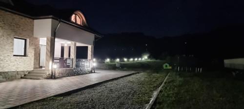 a building with lights on the side of it at night at Pensiunea Sofia in Telciu