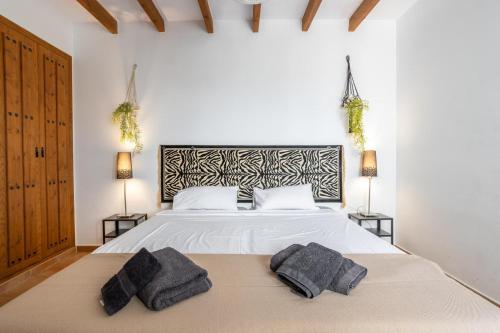 a bedroom with a bed with two pillows on it at Casa Rural 7 dormitorios Cómpeta con Piscina Vallada Barbacoa by CostaDelSolEscapes in Málaga