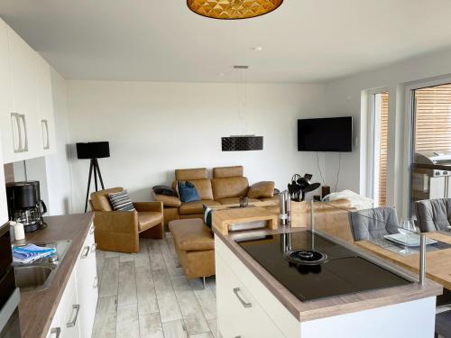 a living room with a couch and a table at Exklusives Apartment mit Blick auf den See in Großräschen
