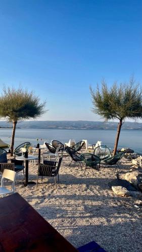 a group of chairs and tables and trees on a beach at Ferienwohnung Dalmatien in Dugi Rat