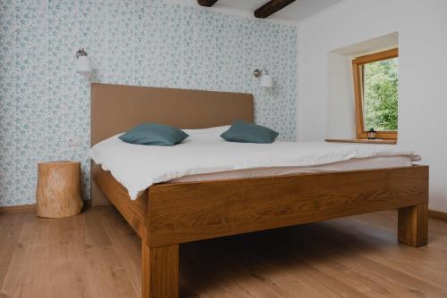 a bed with two blue pillows in a bedroom at Gorska Vila mountain villa in Soča