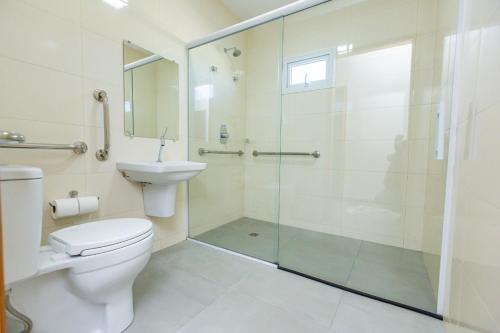 La salle de bains est pourvue d'une douche, de toilettes et d'un lavabo. dans l'établissement Hotel Zandoná, à Joinville